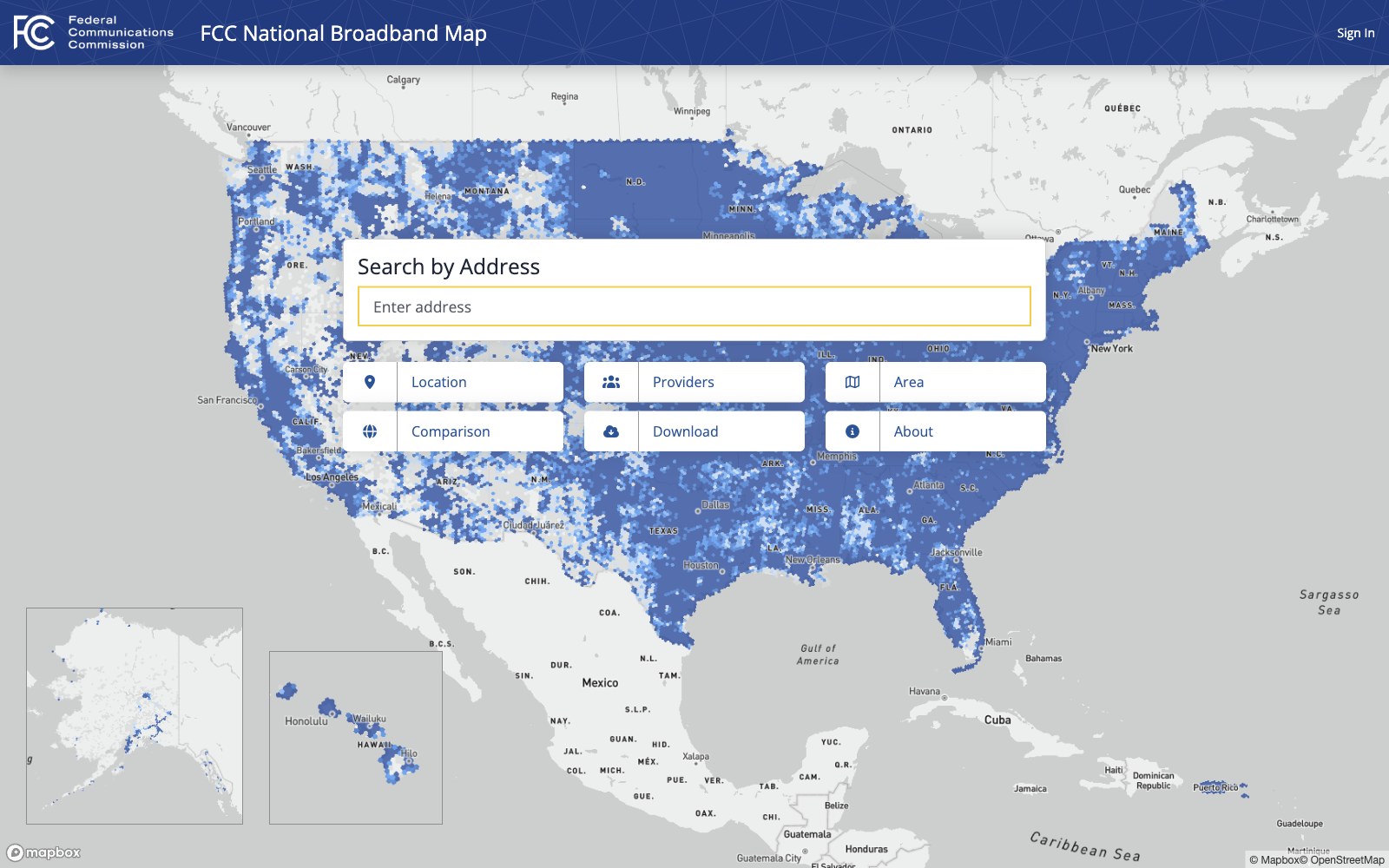 The FCC national broadband map displayed on a desktop monitor, showing a residential area with served and unserved address markers