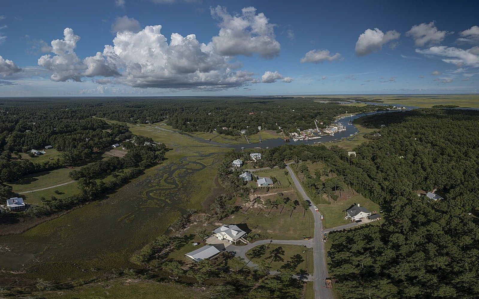 Aerial view of coastal homes scattered along a winding tidal marsh and river