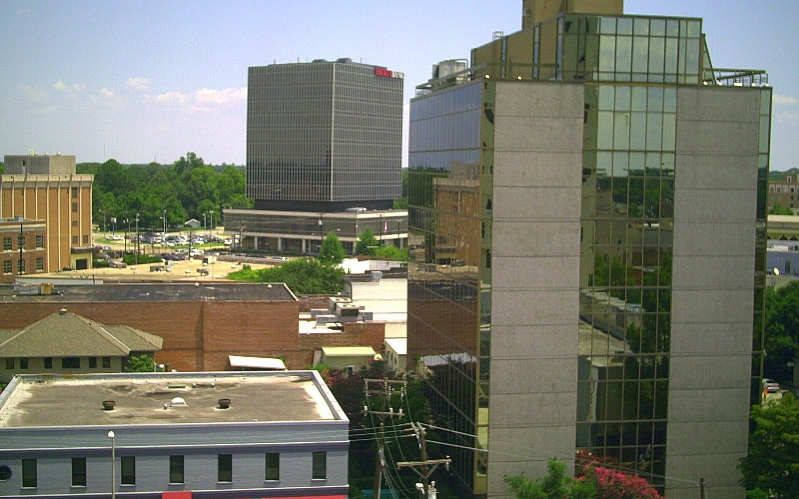 Downtown skyline with glass office towers rising above lower brick buildings and rooftops